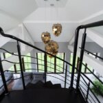 Moderne Loft-Stil Pendelleuchte in einem urbanen Wohnraum mit hohen Decken und unverputzten Wänden.